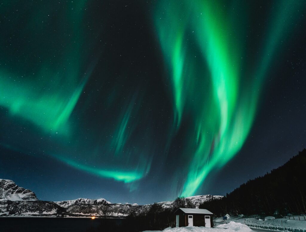 Noorderlicht boven een bergachtig winterlandschap