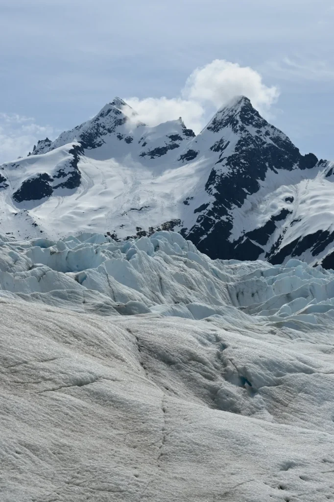 Gletsjerijs en besneeuwde bergtoppen in Alaska onder een bewolkte hemel